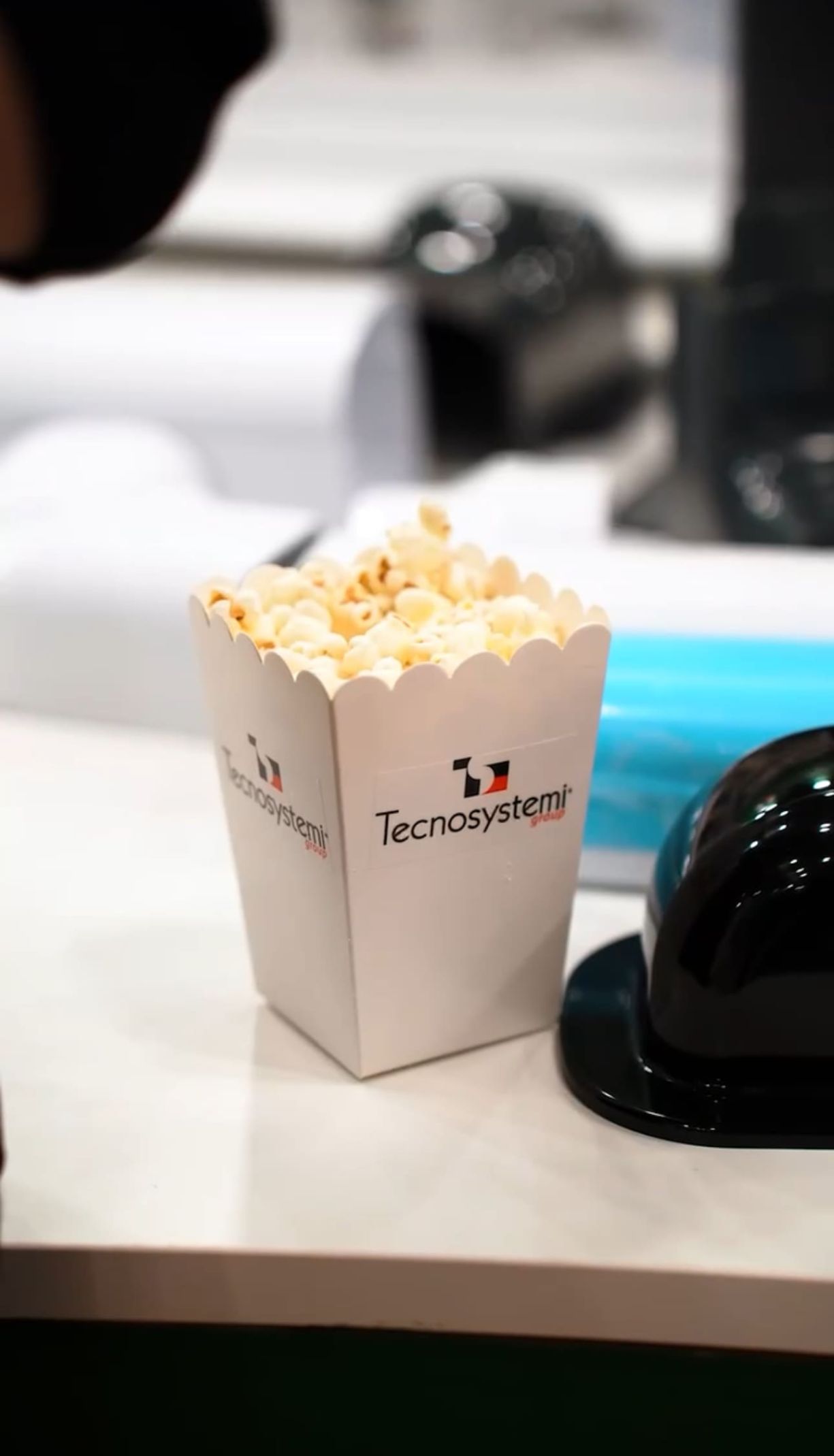 Una confezione di popcorn con logo Tecnosystemi