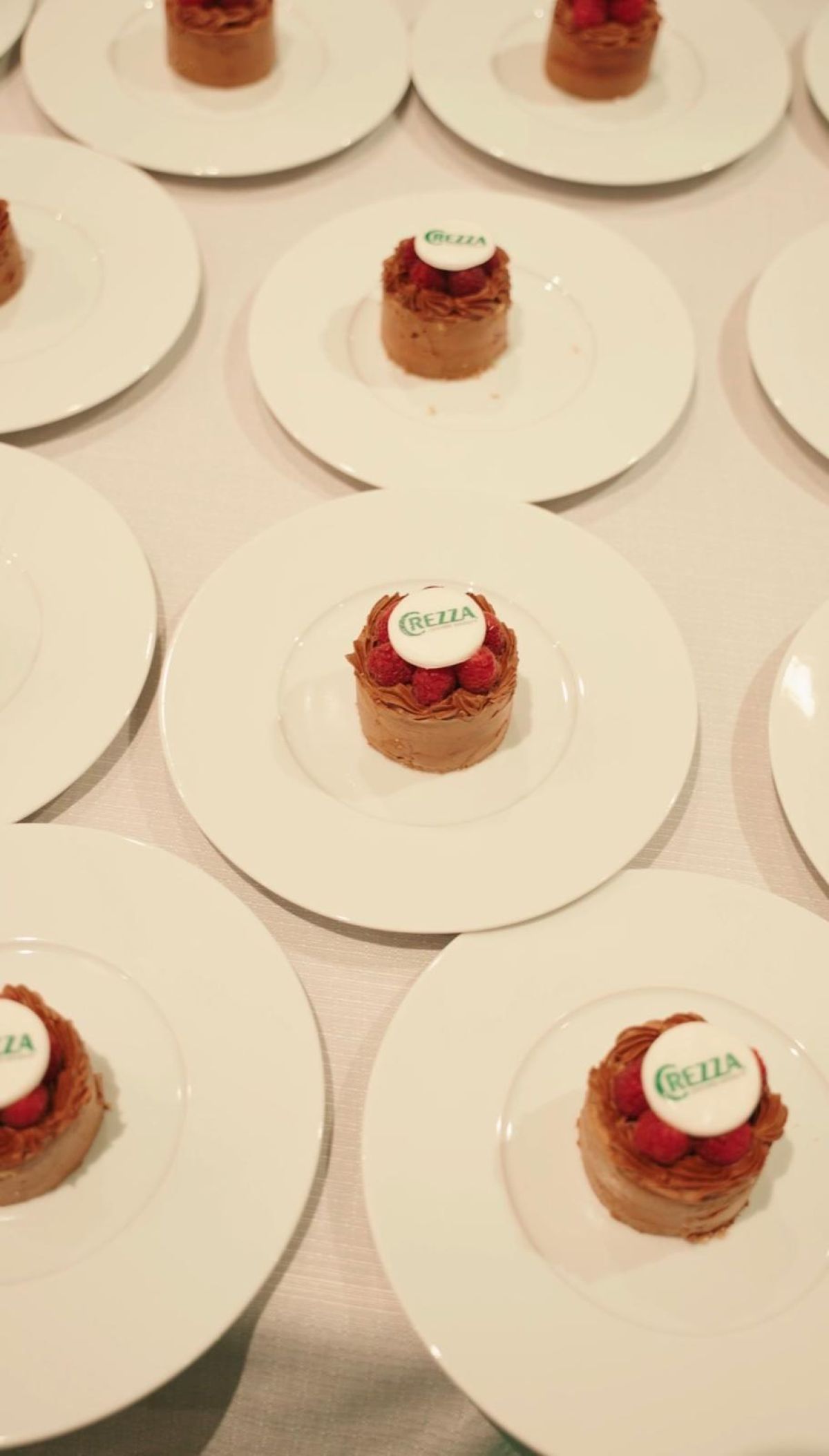 Piatti di dolci monoporzioni al cioccolato e lamponi con decorazione brandizzata studiati da Zeta Eventi Milano