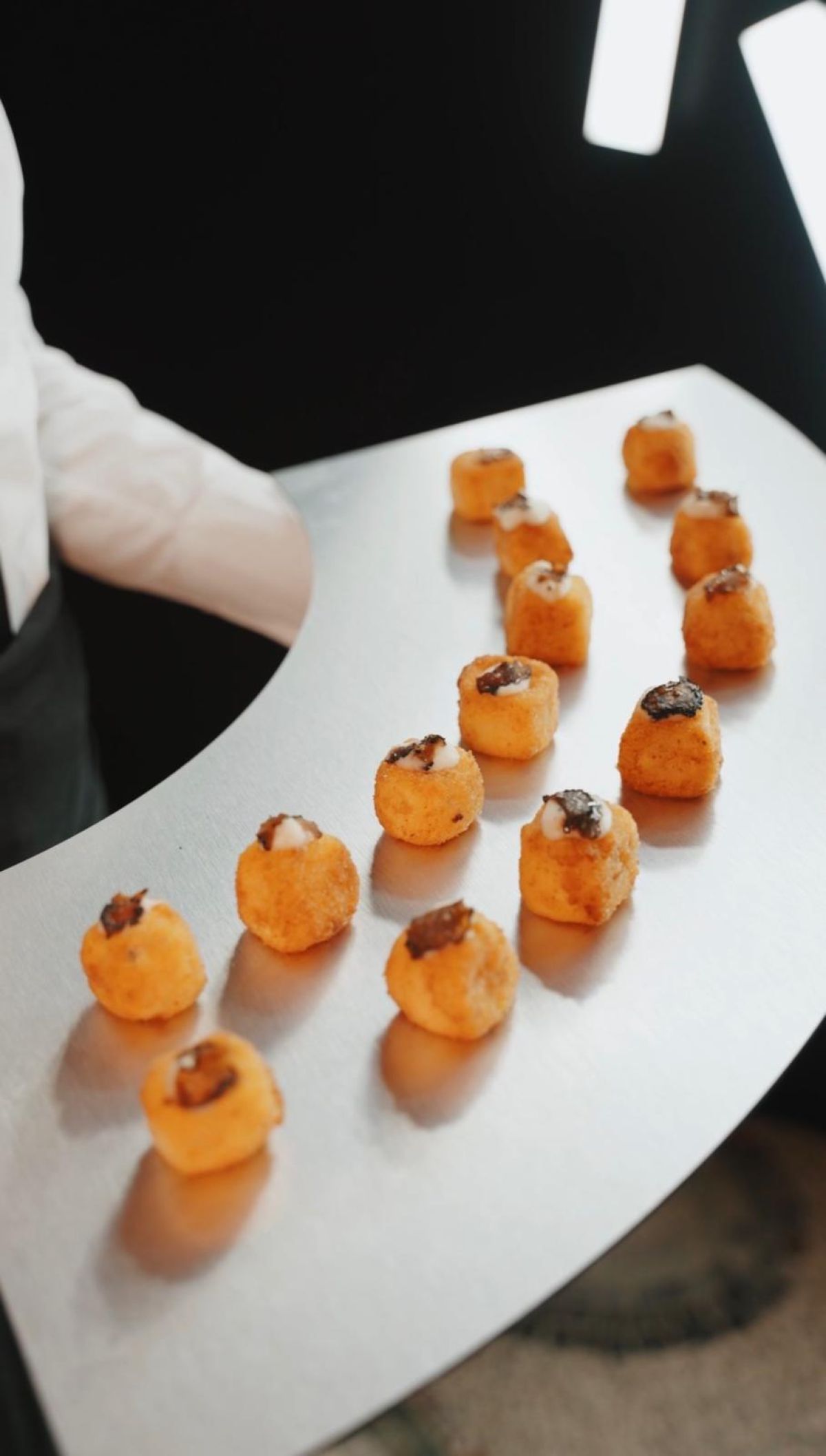 Cameriere con vassoio acciaio con bon bon salati al cocktail in Galleria Meravigli Milano