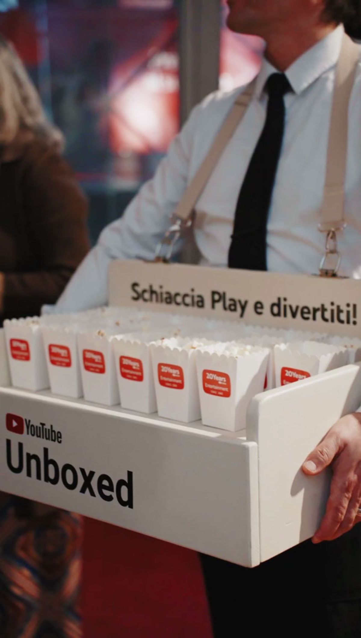 Cameriere con banchetto portatile logo YouTube serve pop corn in contenitori con logo azienda per festa 20 anni di l'ho visto su YouTube Zeta Eventi Milano