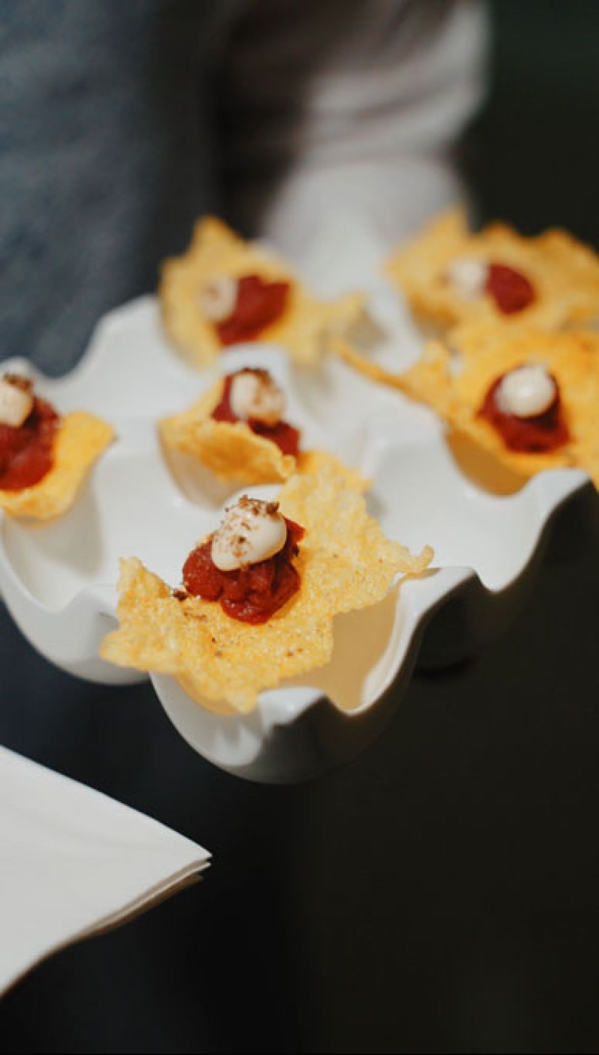 Un cameriere passa fra gli ospiti con un vassoio di pizza fritta preparata al momento per l'aperitivo