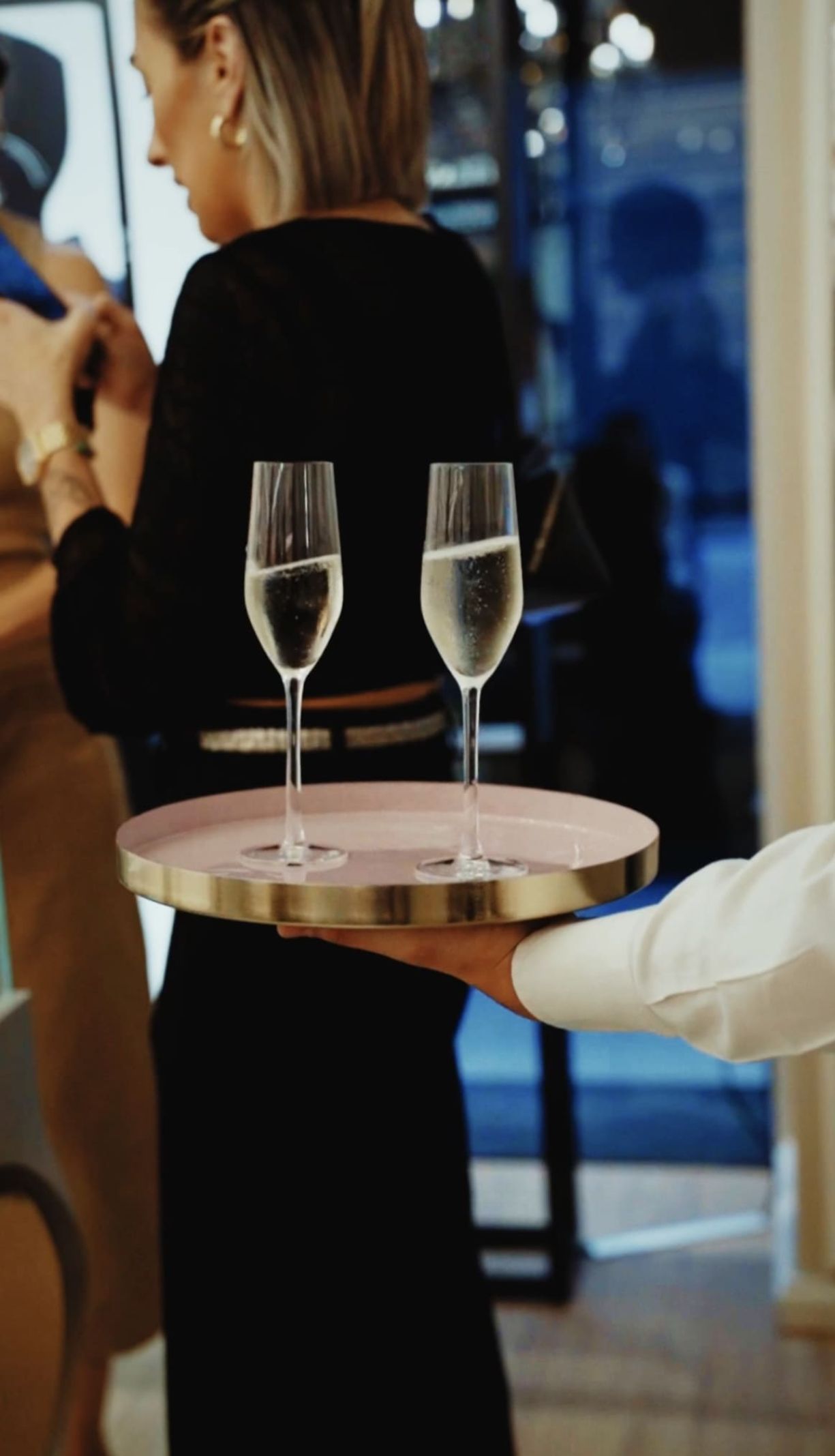 Cameriere serve due calici di spumante su vassoio tondo by Zeta Eventi Milano