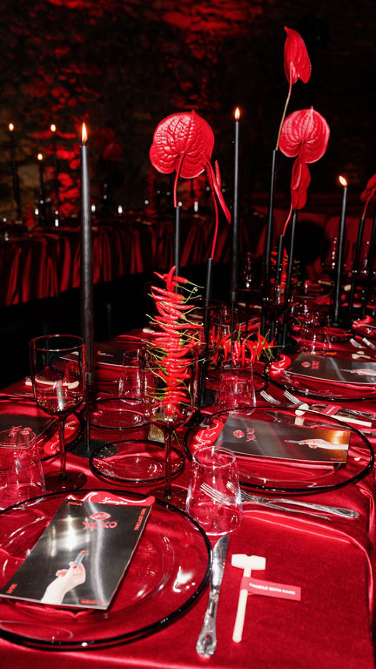 Dettaglio mise en place tovaglia, peperoncini, candele e fiori rossi a tema su concept design di Zeta Eventi Milano