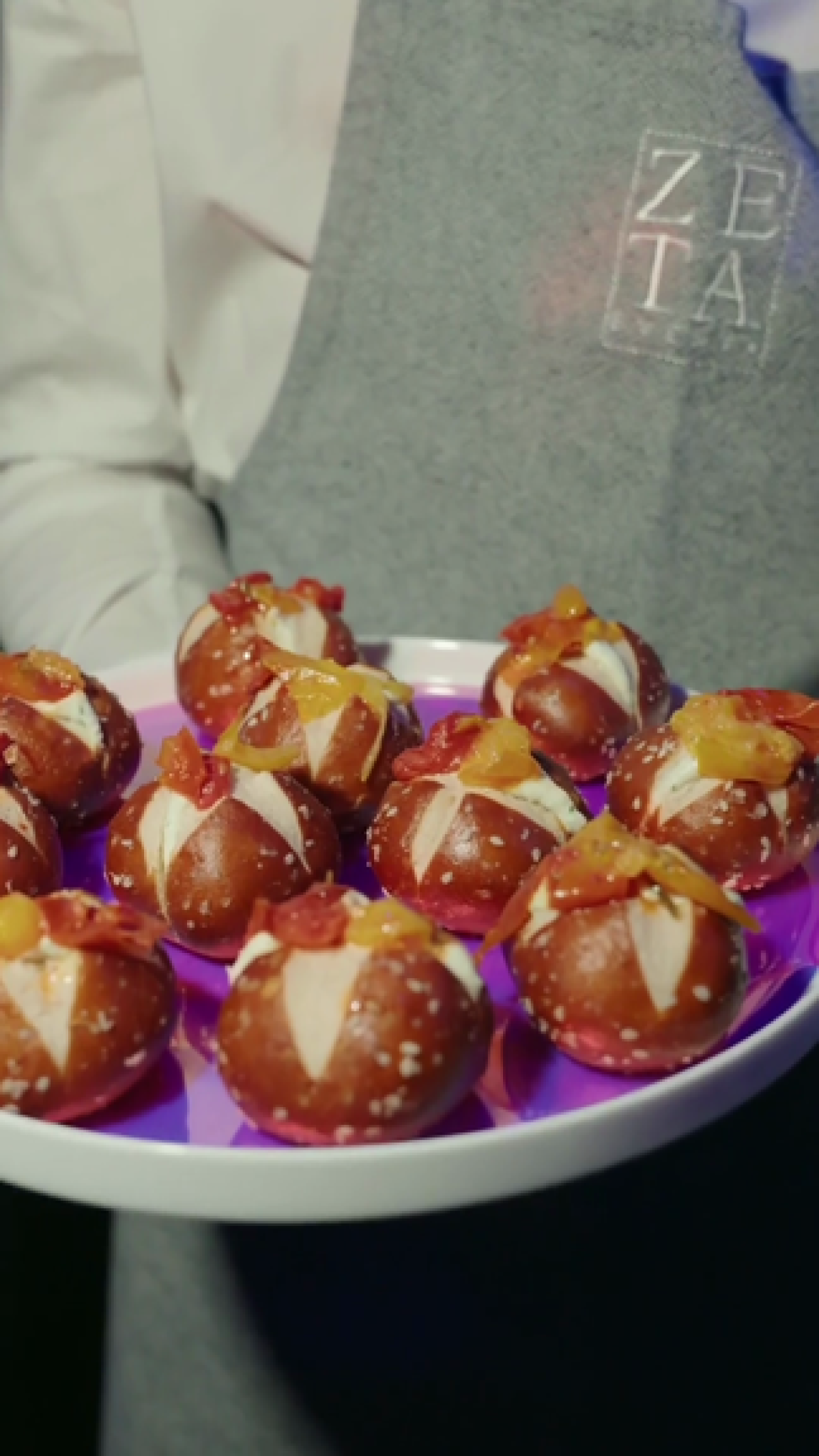 Un cameriere di Zeta Eventi offre un vassoio di mini bretzel farciti agli ospiti di Google Think Future 2025 Milano