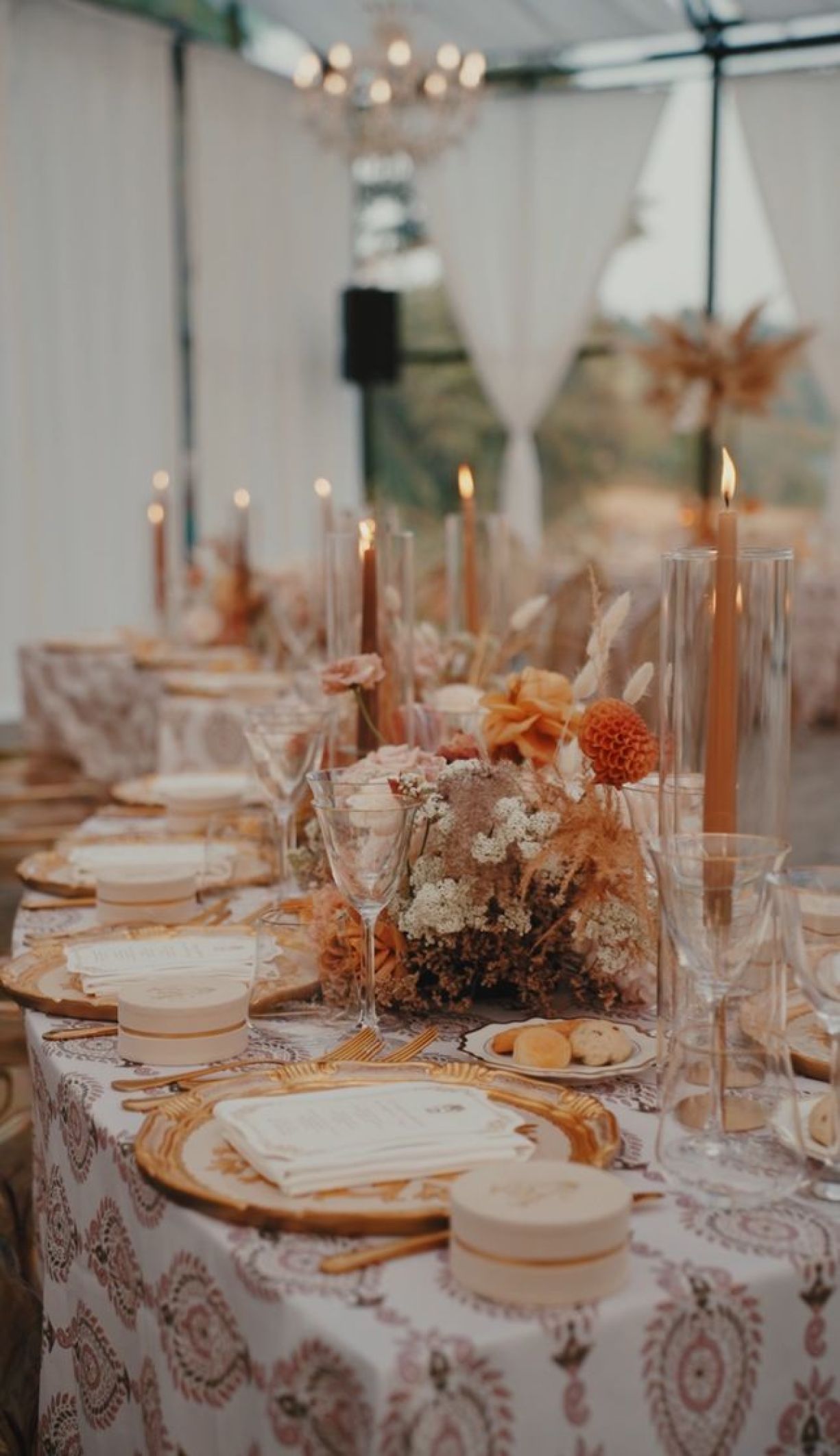Tavola dinner matrimonio con fiori cipria e ocra candele accese dettagli in oro