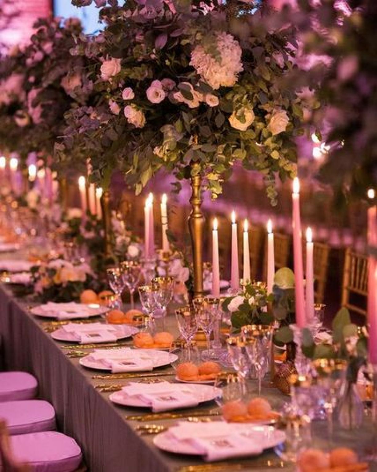 Tavola cena matrimonio con dettagli rosa, candele accese e composizioni floreali alte di Zeta Eventi Milano