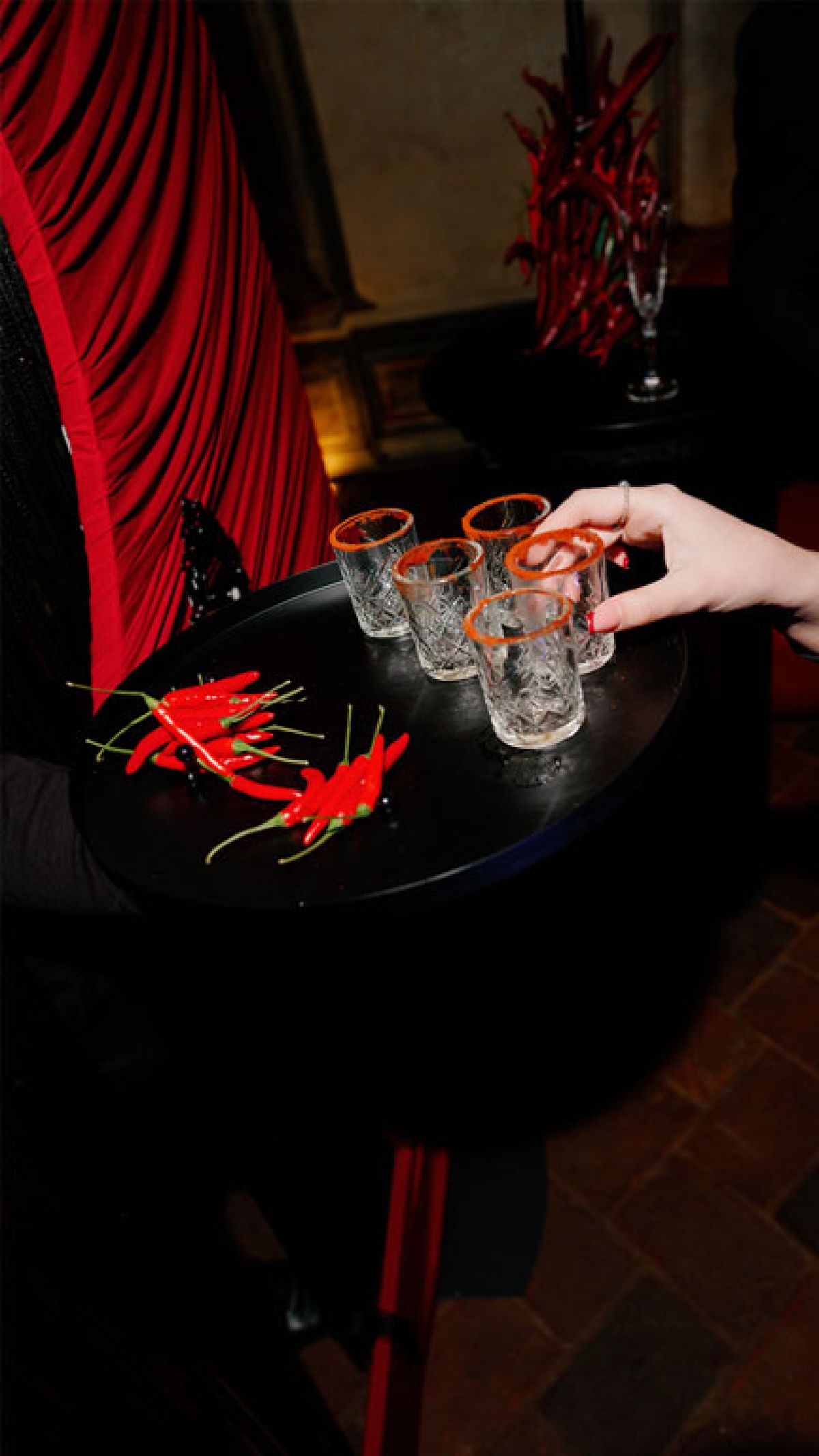 Vassoio aperitivo tequila e peperoncini servito in bicchieri con bordo rosso da Zeta Eventi Milano